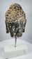 Antique Buddhist sculpture from Southeast Asia with remnants of dark and ochre pigment