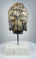 Front view of carved stone Buddha head with serene expression and tightly curled hair