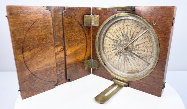 Open mid-19th-century Thomas Jones Liverpool alidade compass in its walnut case, showing the circular silvered degree ring and brass sighting arms.