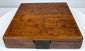 Closed walnut case of a mid-19th-century Thomas Jones surveying compass showing its figured wood grain and aged surface patina.