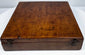 Opposite exterior angle of the walnut instrument case showing its low rectangular profile, hinged construction, and 19th-century surface wear.