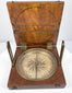 Top-down photograph of the open alidade compass highlighting the silvered degree scale, magnetic needle, and brass sighting components.
