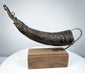 Antique Tibetan carved ritual horn from the Himalayan region, 18th–19th century, with elongated curved form and rich aged patina.