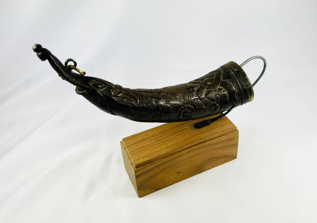 Tibetan Buddhist carved horn ritual implement on wooden display stand.