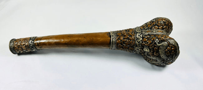 Reverse view of Tibetan human-femur kangling showing engraved metalwork and dragon-form decoration