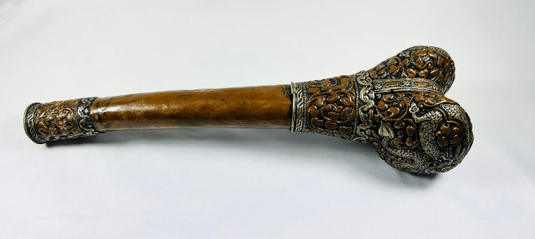 Reverse view of Tibetan human-femur kangling showing engraved metalwork and dragon-form decoration