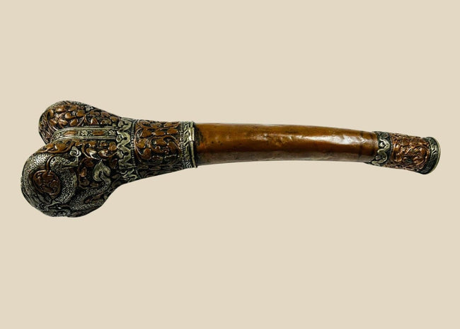 Full-length side view of Tibetan kangling ritual trumpet fashioned from a human femur with ornate metal fittings