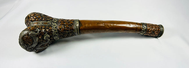 Full-length side view of Tibetan kangling showing the curved human femur shaft and decorated terminal fittings
