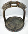 Antique bronze stirrup from the Himalayan region with pierced arch, decorative inlays, and heavy verdigris oxidation.