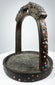 Ornate Himalayan bronze stirrup with pierced latticework, colorful stone inlays, and richly aged green-brown patina.