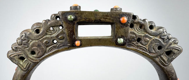 Late Qing dynasty-style bronze equestrian stirrup with pierced metalwork, jeweled inlays, and aged surface encrustation.