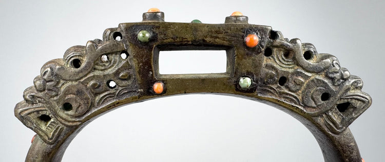 Late Qing dynasty-style bronze equestrian stirrup with pierced metalwork, jeweled inlays, and aged surface encrustation.