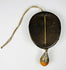 Tibetan devotional mask ornament with leather mounting and drop pendant