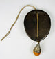 Tibetan devotional mask ornament with leather mounting and drop pendant