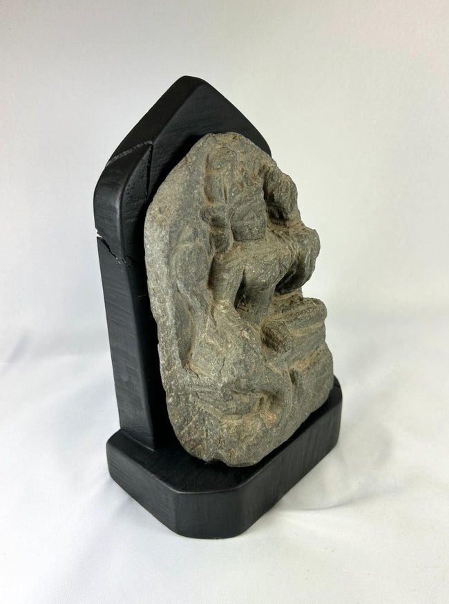 Side view of a medieval Tibetan stone stele showing carved contours and weathered surface