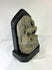 Side view of a medieval Tibetan stone stele showing carved contours and weathered surface