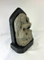 Side view of a medieval Tibetan stone stele showing carved contours and weathered surface