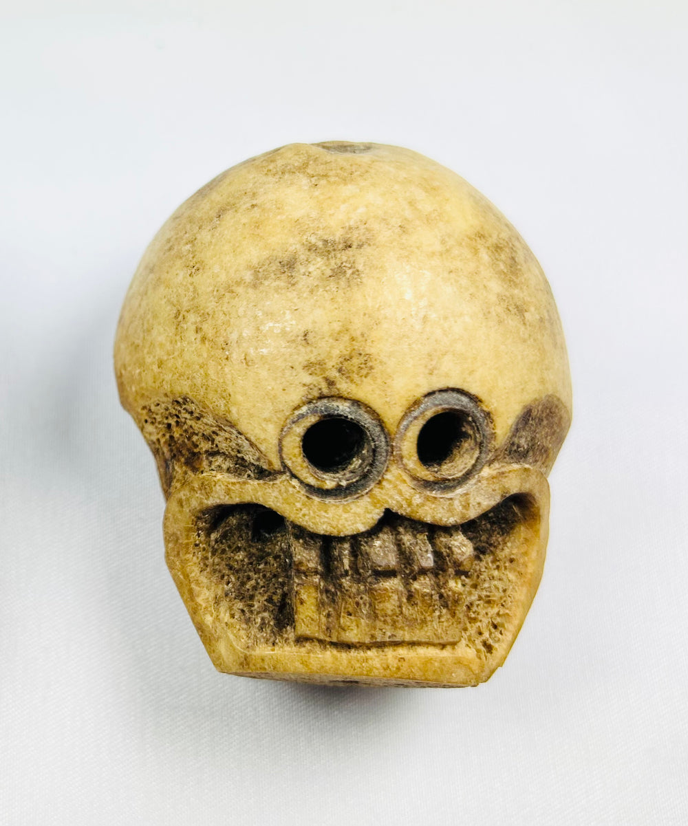 Pair of large 18th–19th century Tibetan Buddhist ritual beads carved from human femur bone, featuring intricate Citipati imagery, vertical suspension holes for stringing, fine patina, and devotional use in meditation on impermanence and mortality