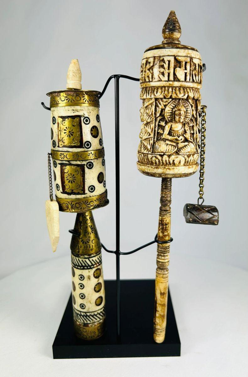 Pair of Tibetan prayer wheels, late 19th century, hand-carved bone, brass, and wood with Buddha figure, mantra script, floral motifs, and custom stands.