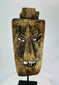 Close-up of facial details on hardwood mask revealing carved teeth, brow ridges, and surface fissures.