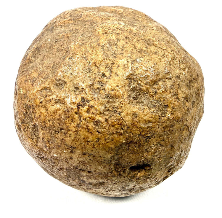 Close-up of dense spherical stone artifact with weathered mineral texture