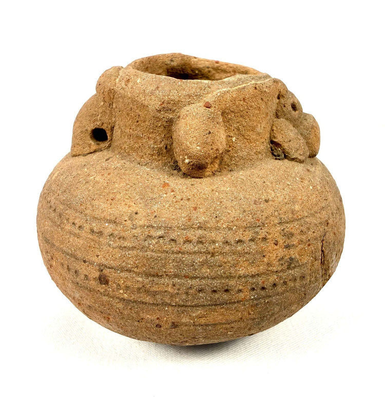 Side view of brown clay vessel with horizontal incised dot patterns