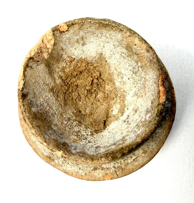 Weathered shallow ceramic bowl with rough textured interior surface