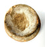Weathered shallow ceramic bowl with rough textured interior surface