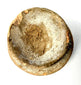 Weathered shallow ceramic bowl with rough textured interior surface