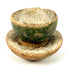 Miniature East Asian green-glazed ceramic cup with pedestal stand, aged surface, rim chipping, and traces of original glaze.