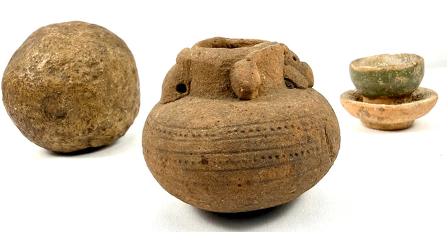 Group shot of ancient stone sphere, decorated pot, and glazed cup