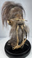 Jivaroan-inspired shrunken head replica displayed beneath a protective glass globe with stitched hide construction and horse hair.