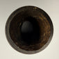 Tibetan human femur bone prayer wheel featuring Buddhist figures and carved inscription band