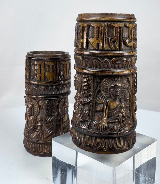 Antique Tibetan ritual prayer wheels fashioned from human femur bone and decorated with symbolic Buddhist devotional imagery.