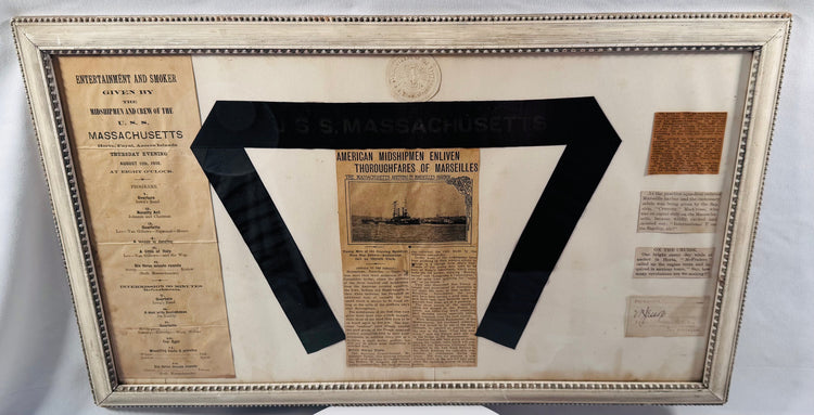 Museum-style presentation of USS Massachusetts naval artifacts including a 1910 entertainment program