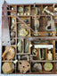 Excavated Civil War artifacts organized in a wooden display tray, featuring Minie balls, buckles, canteen spout, and iron camp tools.