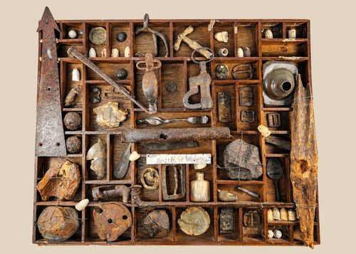American Civil War shadow-box display of dug relics from the Battle of Vicksburg, Mississippi Valley, circa 1861–1865, featuring Minie balls, carved bullets, artillery and shell fragments, US plate and eagle breastplate pieces, spurs, stirrups, buckles, canteen spout, pipe bowl, glass bottle, camp hardware, all mounted in a wooden tray with wire supports and historic hand-written label