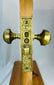 Antique brass door hardware set with floral detailing and demonstration mount