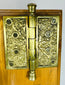 Victorian era brass door hardware with decorative escutcheon and hinge