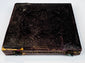 Mid-19th-century photographic case showing embossed floral ornament, worn spine, and original metal closure hardware