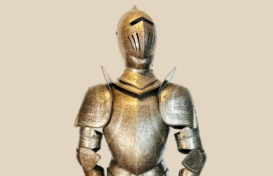 Victorian-era full suit of armor, early 19th century, 80 inches tall by 32 inches wide. Acid-etched metal plates decorated with intricate engravings of mythical creatures, dragons, crowns, battle scenes, and scrolling foliage. Inspired by 15th-century medieval armor, reflecting Victorian fascination with chivalric ideals and Gothic artistry. Mounted on a custom wooden display stand.