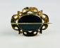 Detail of Gothic Revival openwork on a gold-plated Victorian mourning brooch.