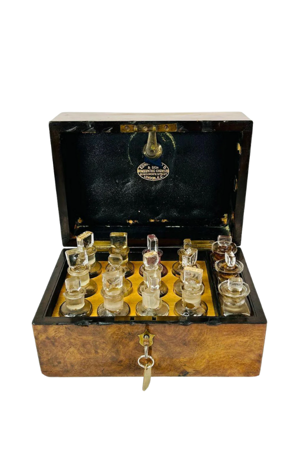 Antique Victorian traveling glass service set with small glass vessels arranged in a fitted wooden case with key