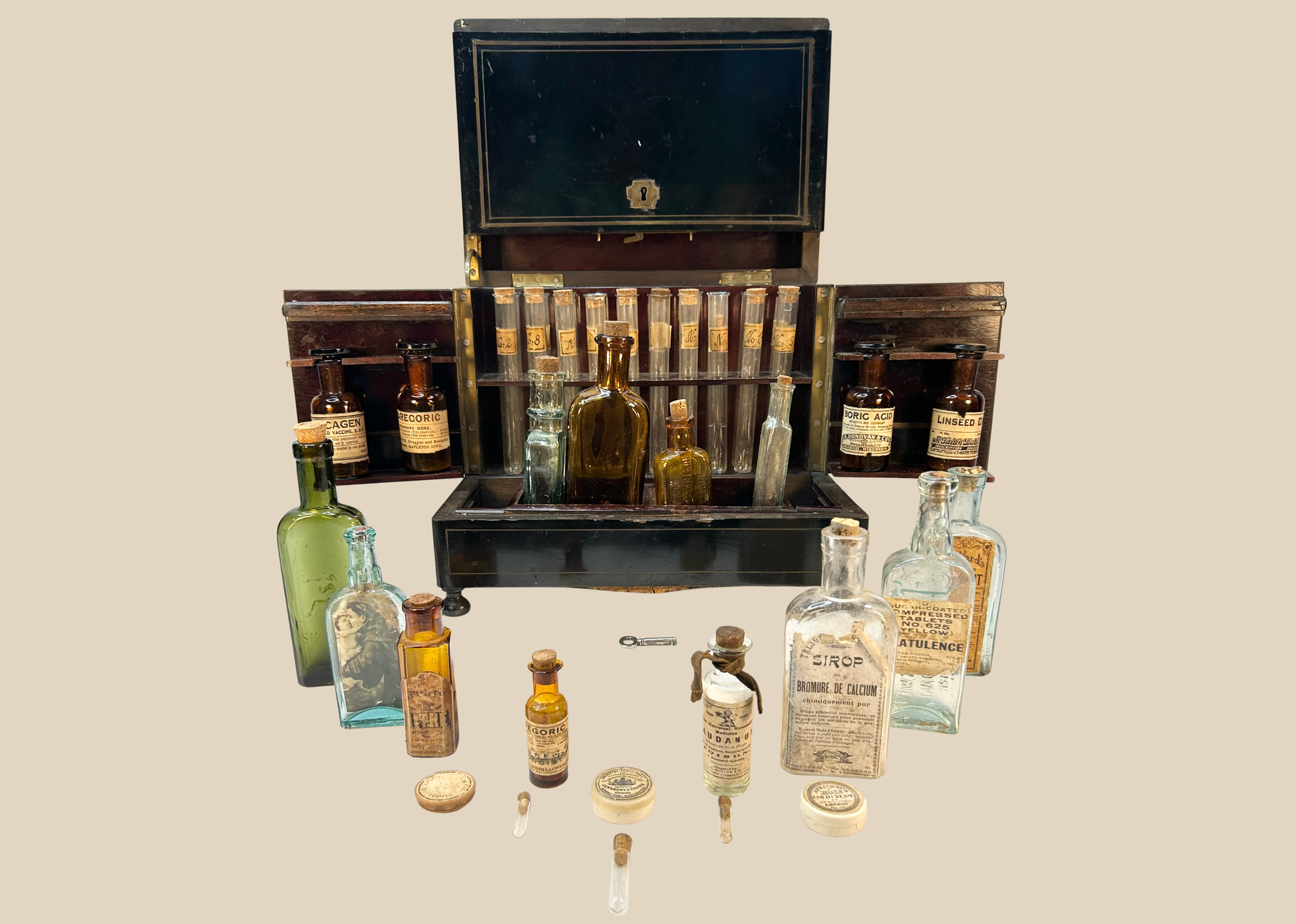 Victorian traveling apothecary cabinet opened to display antique medicine bottles and test tubes