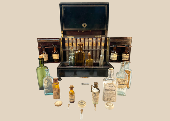 Victorian traveling apothecary cabinet opened to display antique medicine bottles and test tubes