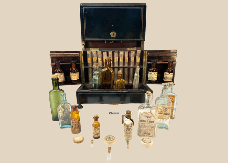 Victorian traveling apothecary cabinet opened to display antique medicine bottles and test tubes