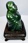Opposite side view of carved Chinese Budai figure showing polished hardstone and layered robe folds