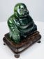 Three-quarter view of dark green Chinese Laughing Buddha figure on carved wooden display stand