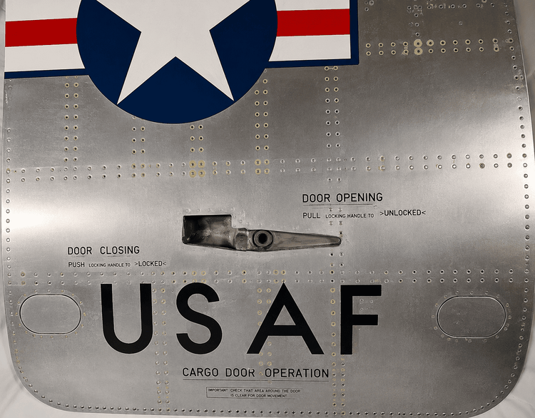 Close-up of the upper USAF Boeing 737 cargo door showing the Star and Bars insignia and aircraft rivet pattern