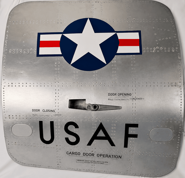 Front view of a vintage USAF Boeing 737 cargo door with military roundel, riveted aluminum skin and original stenciling